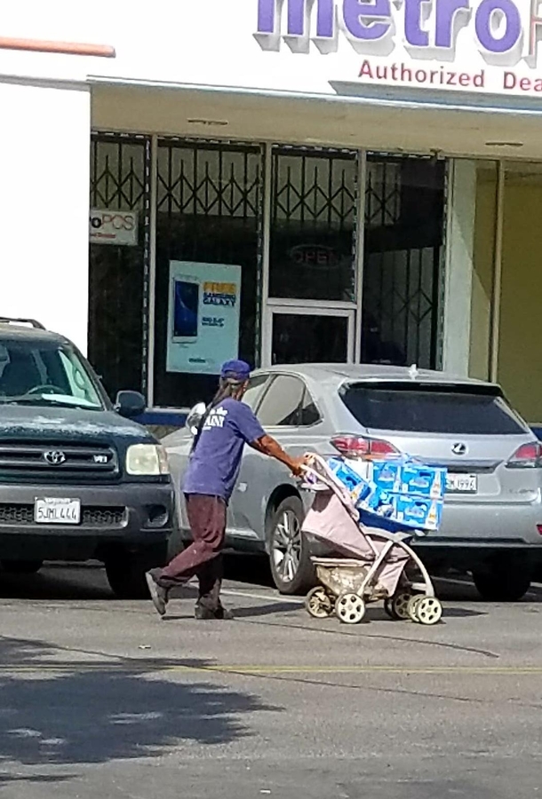 This nice dad is using a stroller to push his newborn baby beers