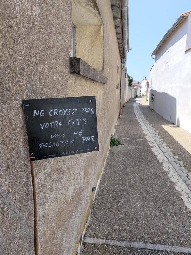 This sign reading Dont believe your GPS you cant fit through here on a tiny street in France
