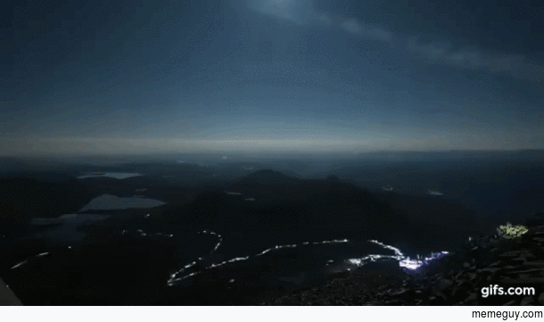 Timelapse of  people with headlamps hiking down a mountain at night