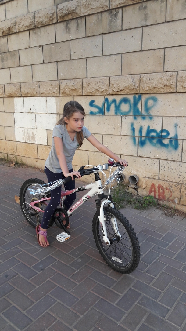 Took a pic of my kid on her new pimped up bike didnt pay attention to the graffiti in the background