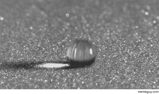 Water droplet falling unto sand