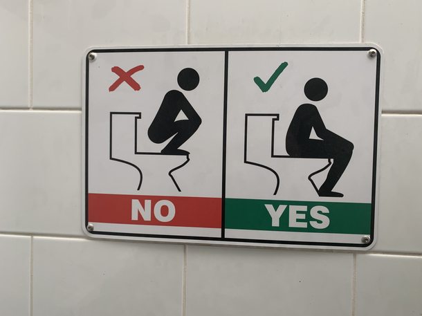 What incident led to this sign being required in a public toilet