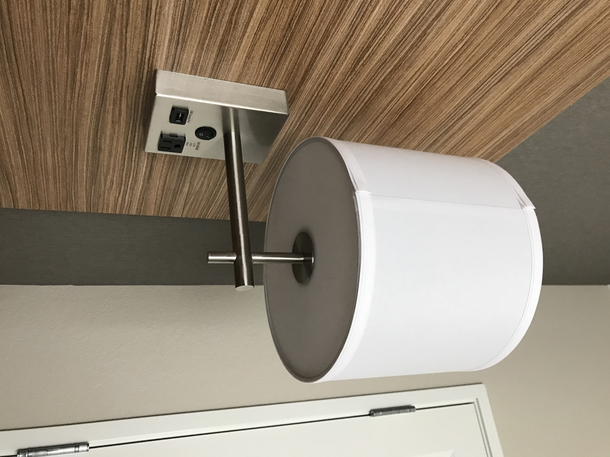 Woke up looked up saw this and figured I must still be dreaming because why else would a giant roll of precious toilet paper be available to me if it wasnt a dream I was awake - its just the bedside lamp at my hotel