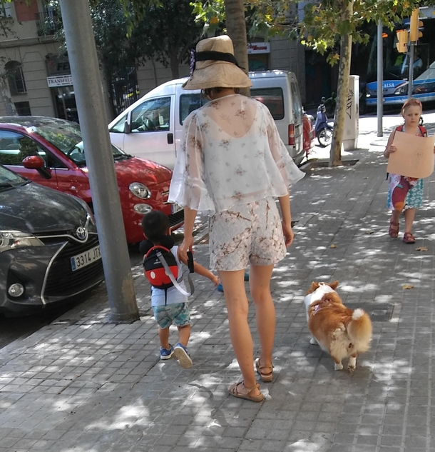 Woman walking her child on a leash and her dog without a leash