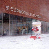 A cup noodles shoveling snow