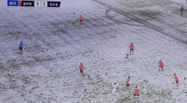 A football team with white jersey in a heavy snow