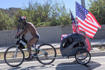 A guy wearing American can boxers an American helmet a gas mask and he has  flags on his bike Now this is something you dont see everyday