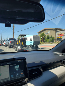 A truck towing a buggy thats towing a teeny tiny camper Its like the nesting doll of towing