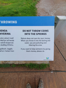A warning sign in front of a geysir in Iceland