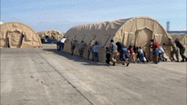 Afghan refugees help Airmen move tents