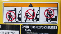 As far as I can tell this warning sticker appears to be advising against performing Singin in the Rain on the front of this forklift