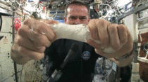 Astronaut wringing a wash cloth in space