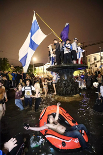 Finnish hockey fans at the Havis Amanda fountain in Helsinki shortly after Finland won the ice hockey world championship This looks like some sort of renaissance painting
