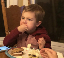 Four year old nephew angrily shoving an ice cream sandwich into his mouth