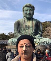 Grinning statue with a plain faced man