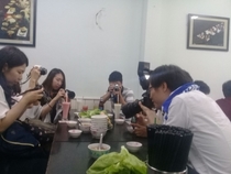 Japanese tourists next to me in a noodle kitchen in Saigon The waiter just brought a plate of lettuce