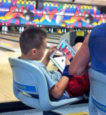 Kid literally playing bowling on a bowling alley