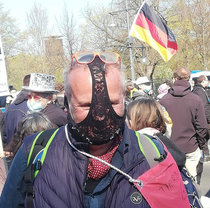 Man demonstrates in Berlin with woman underwear over his face