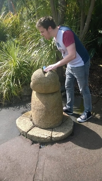My boyfriend drinking from a Koru shaped water fountain at Auckland Zoo Perspective is everything