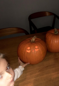My daughter proudly presenting her most creepy pumpkin carving to date