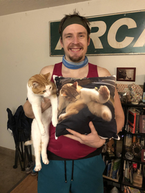 My husband posing with the pillow I had made for him of our cat for Christmas