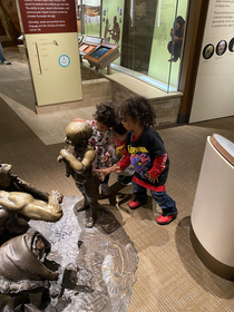 My kids checking out a statue in a museum