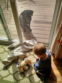 My son feeding his fake dog goldfish while his real dog sits outside pissed