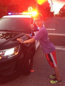My son needed to have a recent photograph for a high school hes applying to This morning we ran a race that required local roads to be closed off A police officer at the starting line humored us with this picture and even offered to put him in cuffs