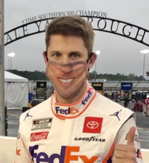 NASCAR driver Denny Hamlin wears a mask with his own face on it before the race