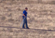 Nik Wallenda wipes his shoes at  feet in the air