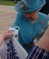 Old Glaswegian woman handing the queen a bag of toys from BampM saying Theyre for wee george