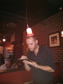 Our waiter got tired of hitting his head on the light His solution