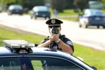 Police officer choking a small robot