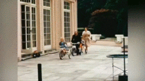 Prince Philip and the Queen playing with little Prince Charles and Princess Anne