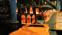 Red hot glass bottles being formed at a recycling plant