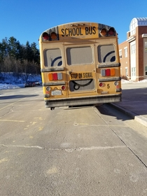 Someone drew a face in the dirt on the back of this bus