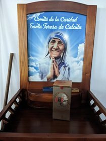 Someone left a bottle of whiskey at a Mother Theresa themed donation table at the church