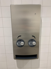 Someone put eyebrows on the feminine product dispenser