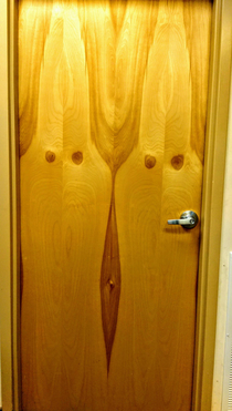The natural wood grain on this door in my office looks like two Klan members