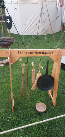 the sign sais weaponstand for woman at a renaissance fair