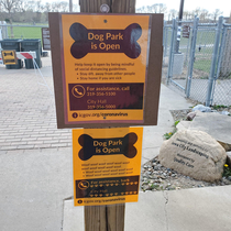 Theres a sign for dogs and a sign for people at the dog park