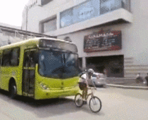 This biker decides to go nice and slow in front of a bus