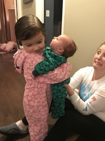 Tried to get a sweet picture of my daughter holding the baby The real gem is my wifes panic face