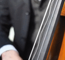 Upright bass player being filmed by a camera with a high shutter speed